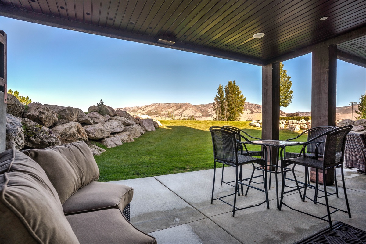 Covered patio with comfortable seating and peaceful mountain surroundings—perfect for morning coffee or evening drinks.