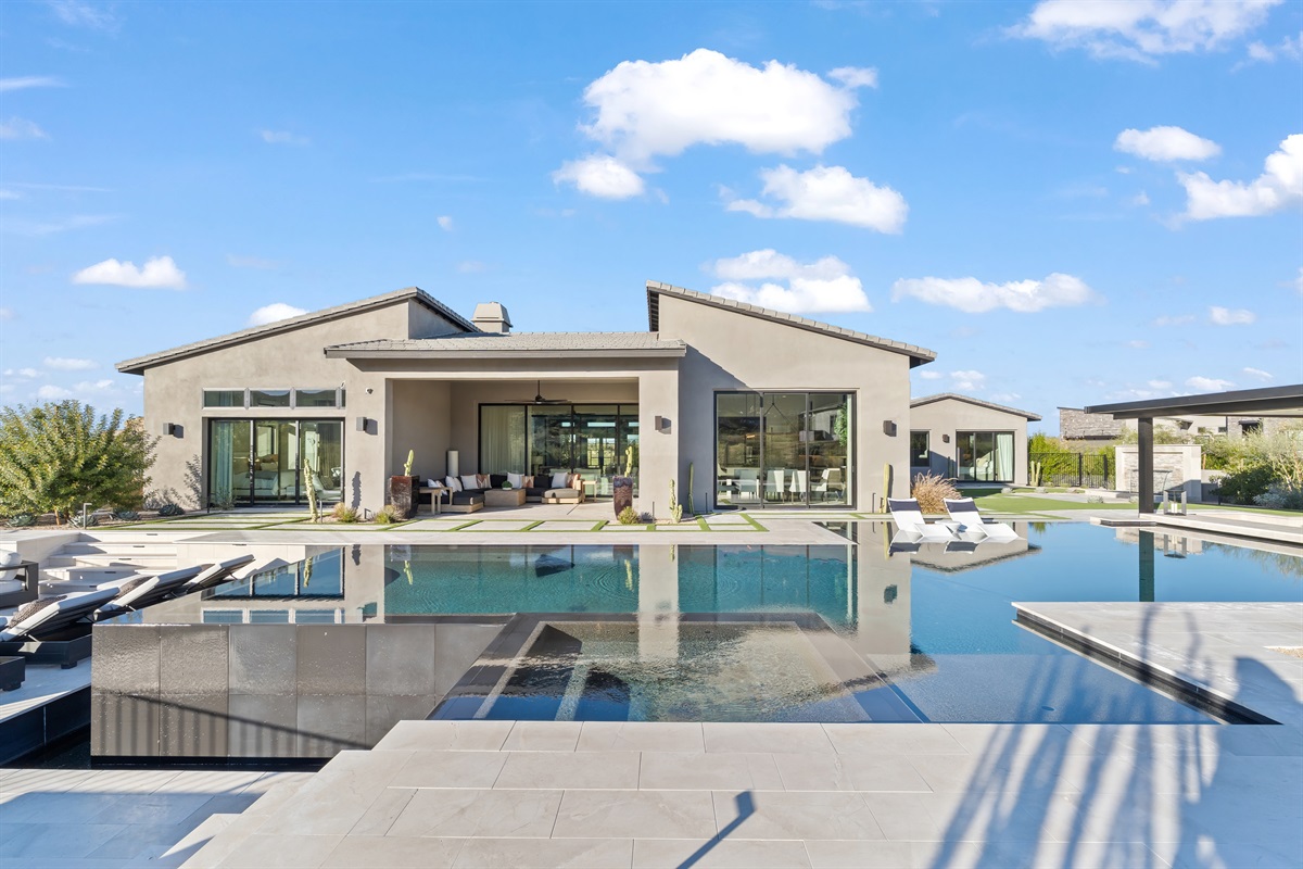 The Backyard: A $1M Private Resort. A zero-edge pool with a swim-up bar and expansive lounge areas.  a