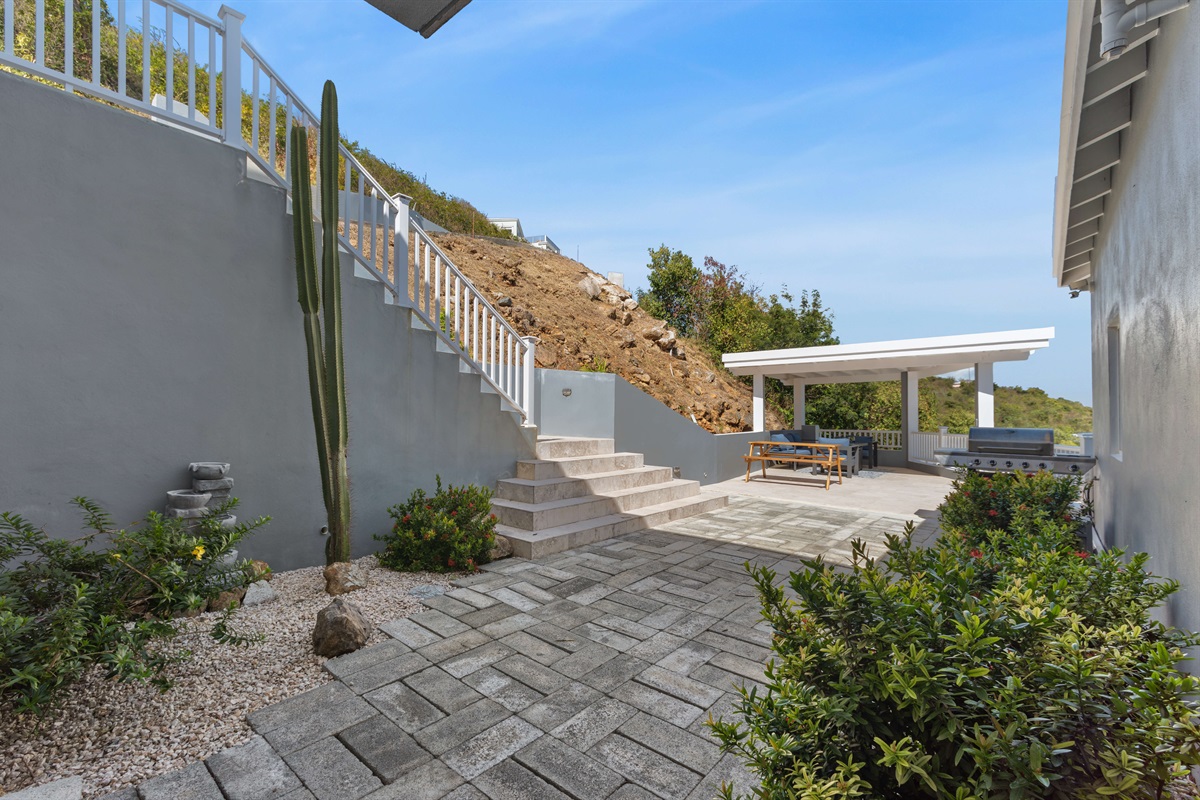 An overview of the villa surrounded by scenic hills and blue waters.