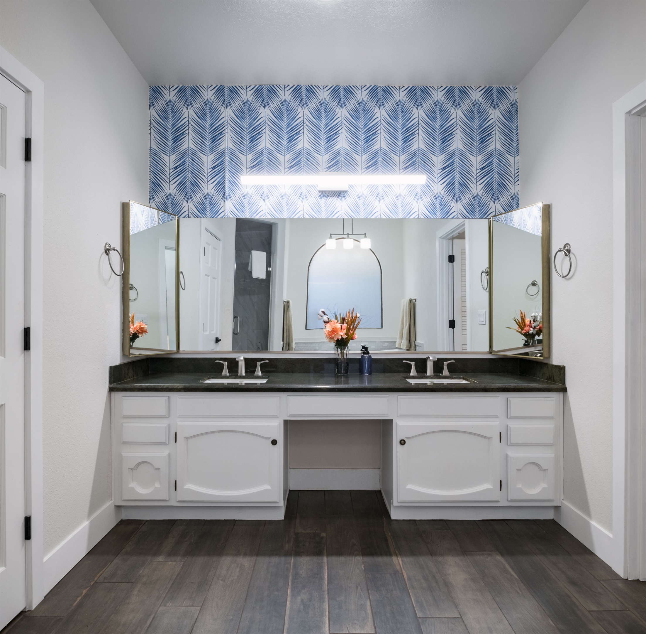 Treat yourself to a stylish bathroom sanctuary with bold wallpaper, dual sinks, and a deep soaking tub perfect for winding down.