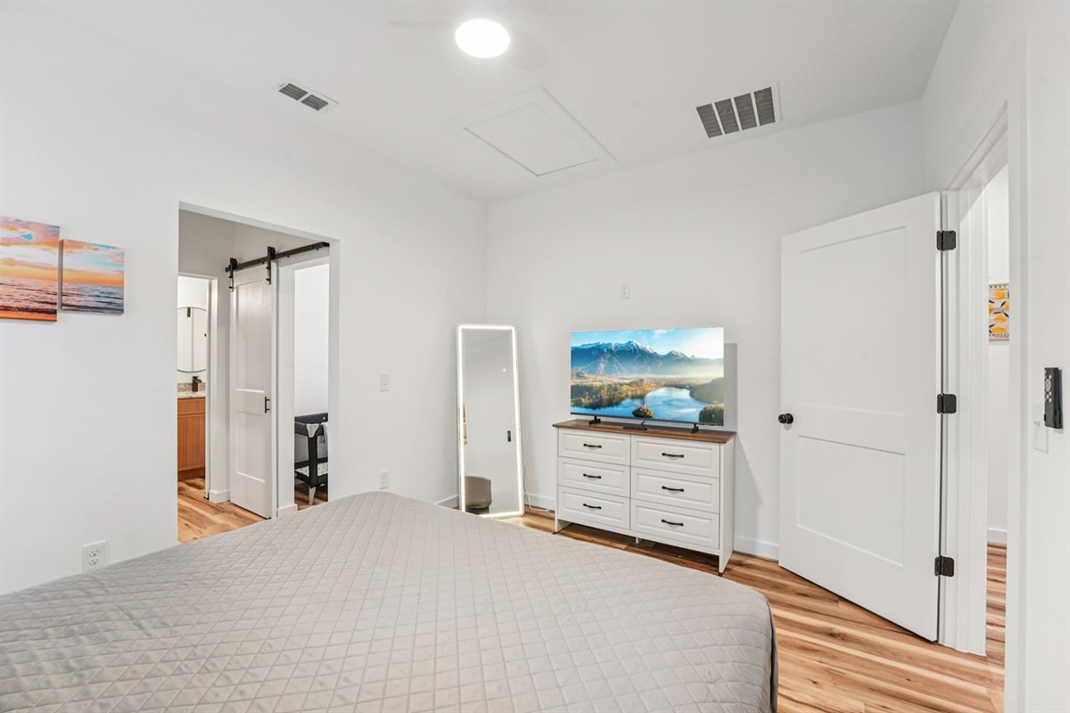 Primary Bedroom has a King size bed, ensuite bathroom with walk-in shower and double vanity, dresser with smart TV on top, lighted mirror, pack n play and air mattress always available inside the closet.