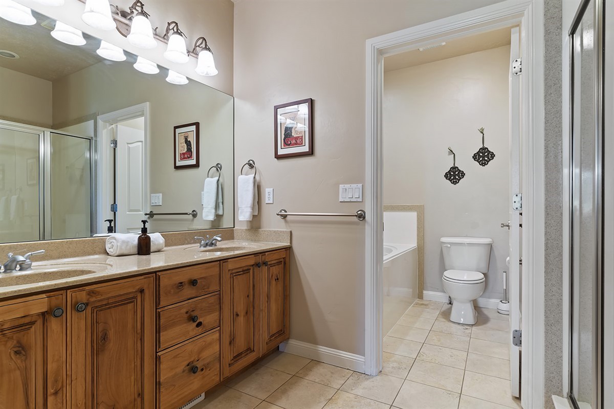 Spacious bathroom featuring a double vanity and a sleek walk-in shower, offering both comfort and convenience.