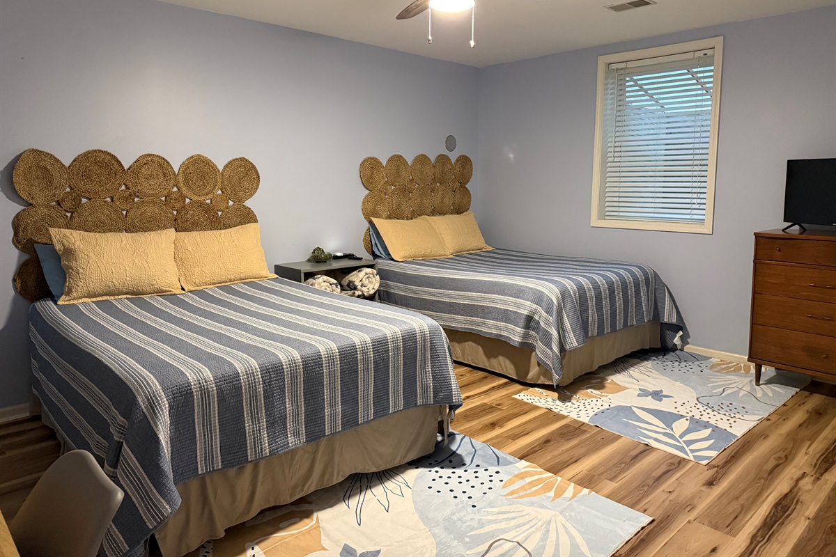 Walkout level bedroom features two queen beds, work desk and smart television.