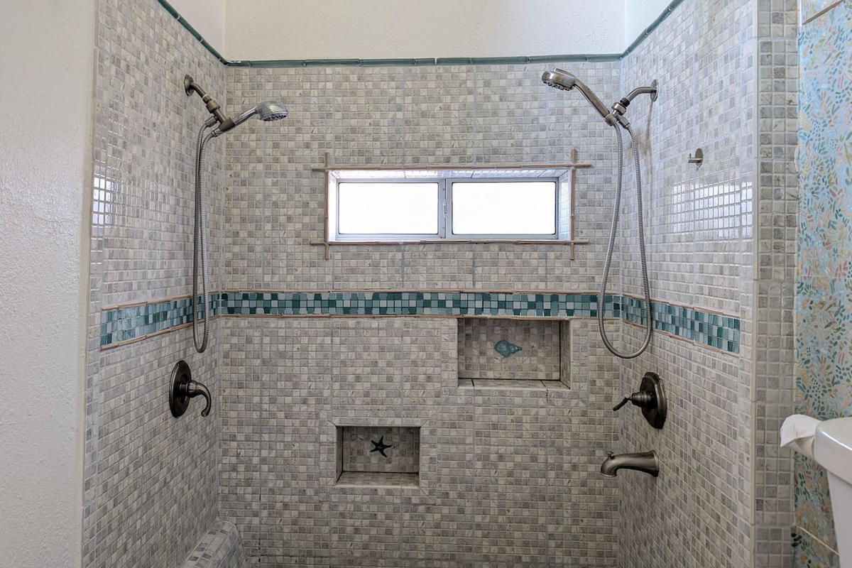 Spacious walk-in shower with dual showerheads. 🚿
