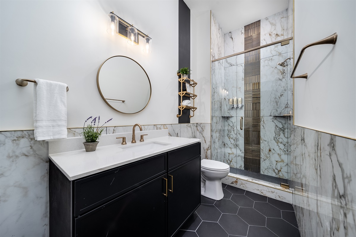 Modern en-suite full bath featuring a glass-enclosed shower and spacious vanity.