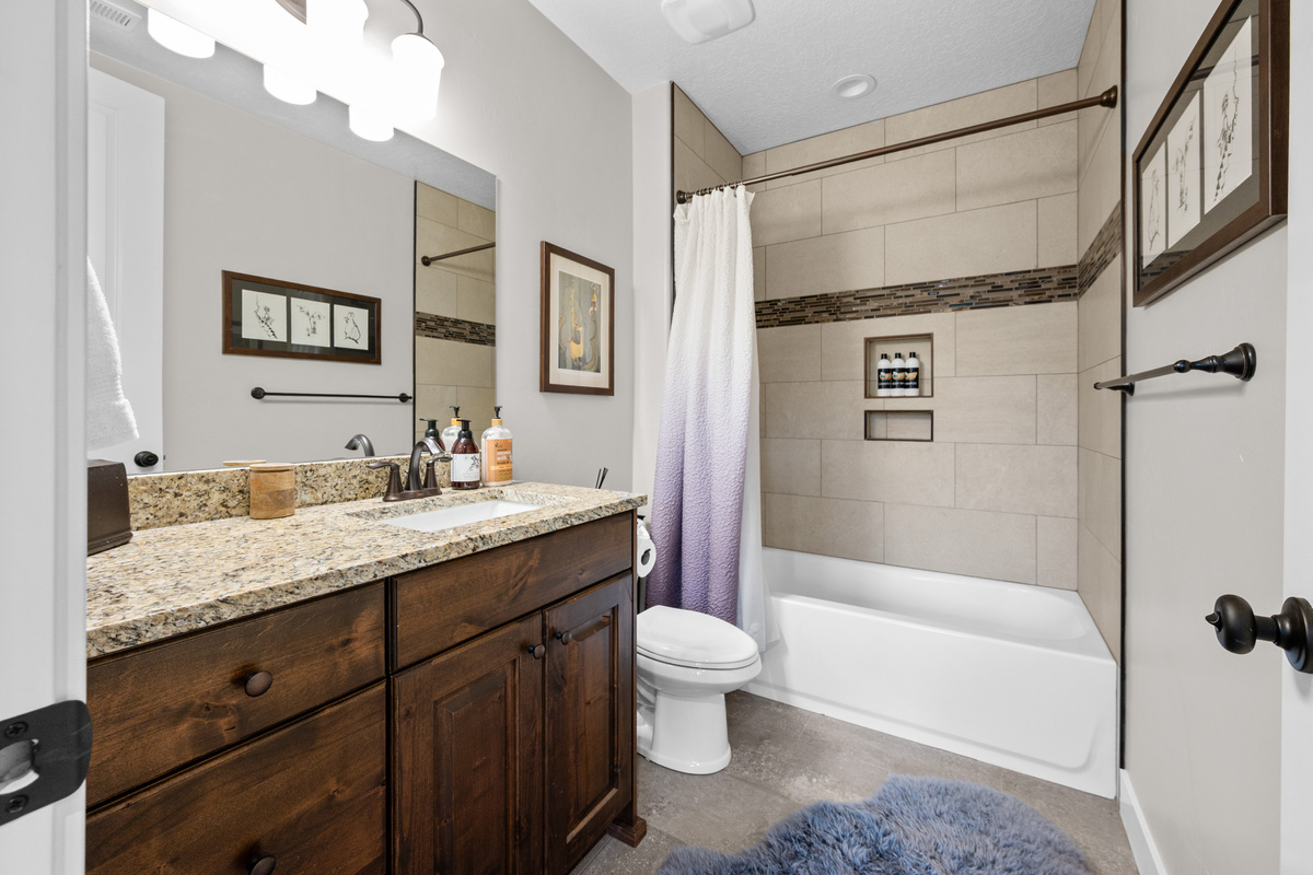 Convenient downstairs bathroom located near the bunk room and workout area with modern finishes throughout.