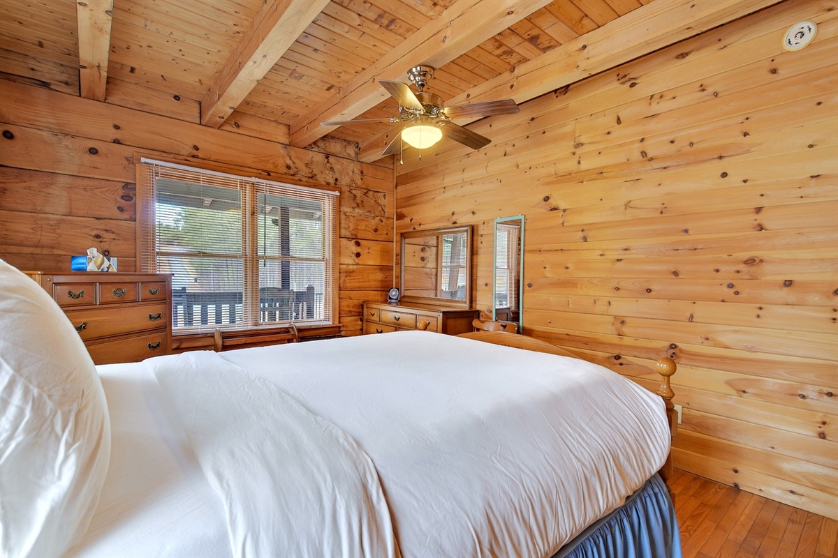 Large windows and a ceiling fan in the main level bedroom 