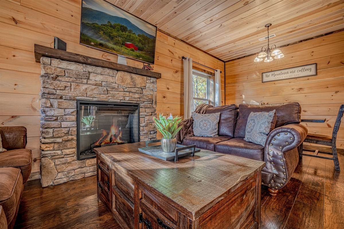 Relax by the stone fireplace with smart TV and comfortable seating.”