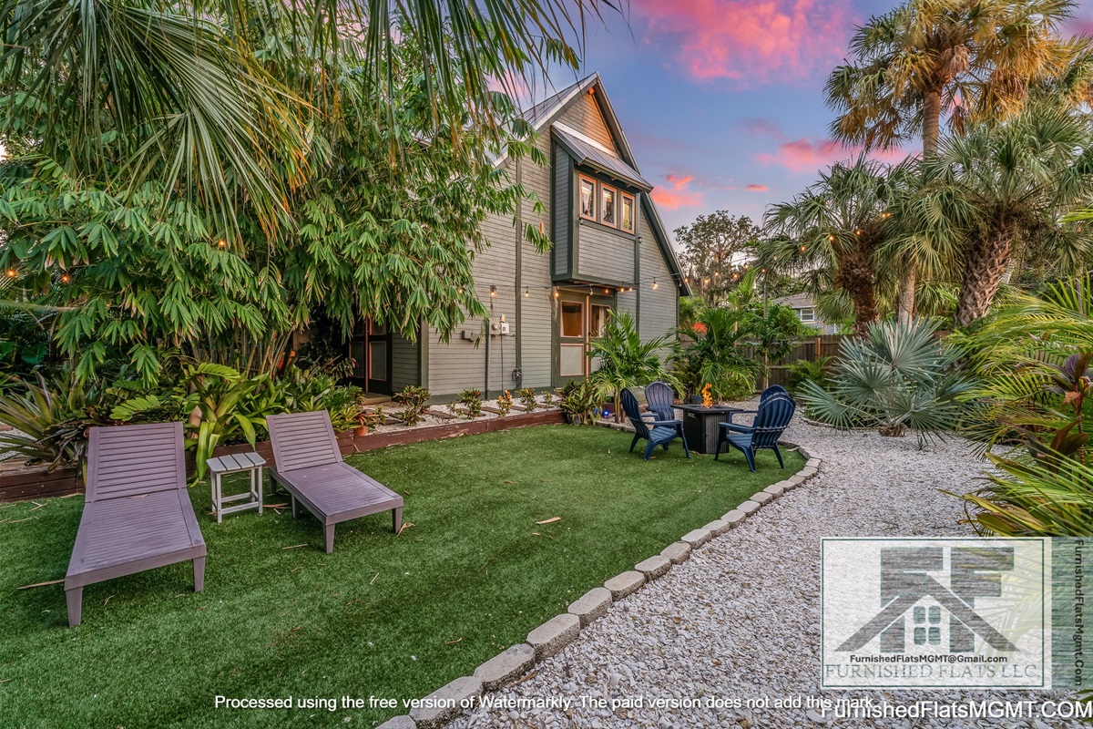 Private secluded yard with firepit and tropical plants