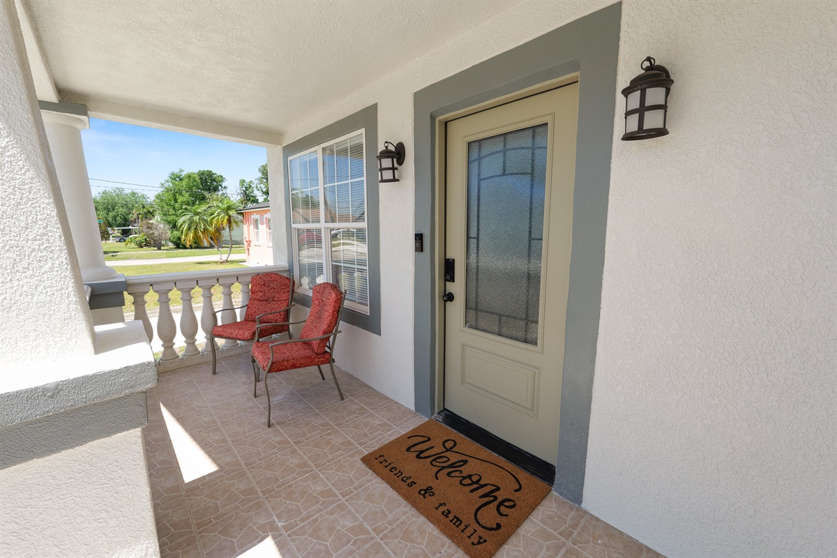 Framed by elegant columns and tropical landscaping, this tiled veranda is the perfect spot for quiet moments or casual conversation.