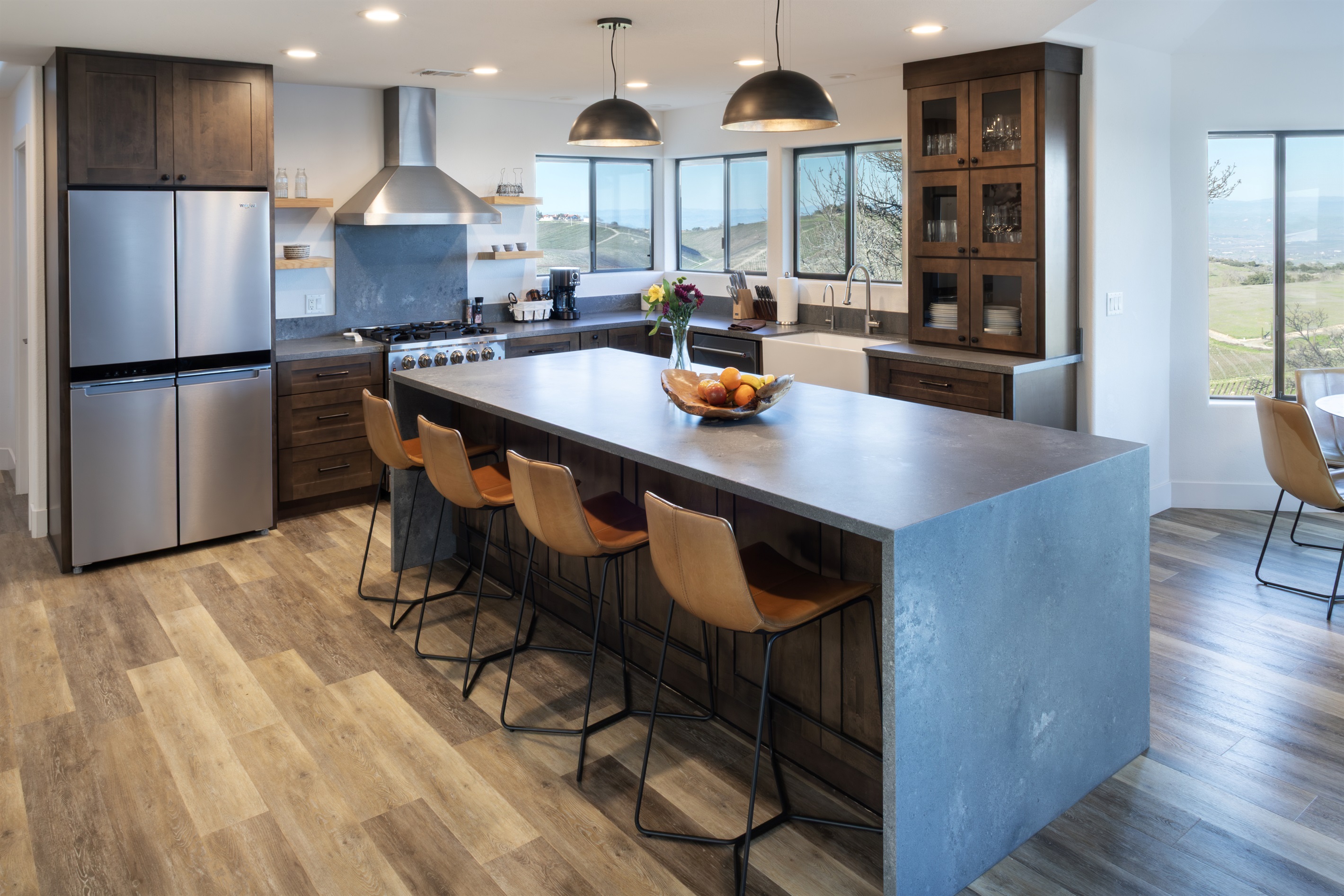 A fully equipped chef's kitchen with professional-grade appliances, a concrete waterfall island, vineyard views from every window, and seating for four at the bar. Cook like a pro or pour a glass and let someone else do it.