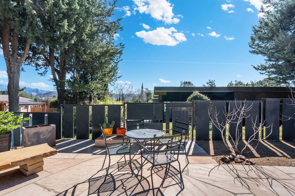 Peaceful patio retreat with café-style dining, privacy fencing, and mountain views — a quiet spot to enjoy morning coffee or unwind under the desert sky.