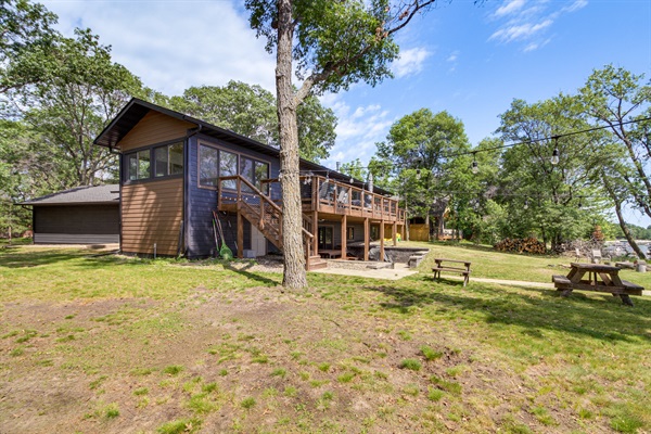 Spacious lakeside yard with fire pit seating and easy access to the beach and dock