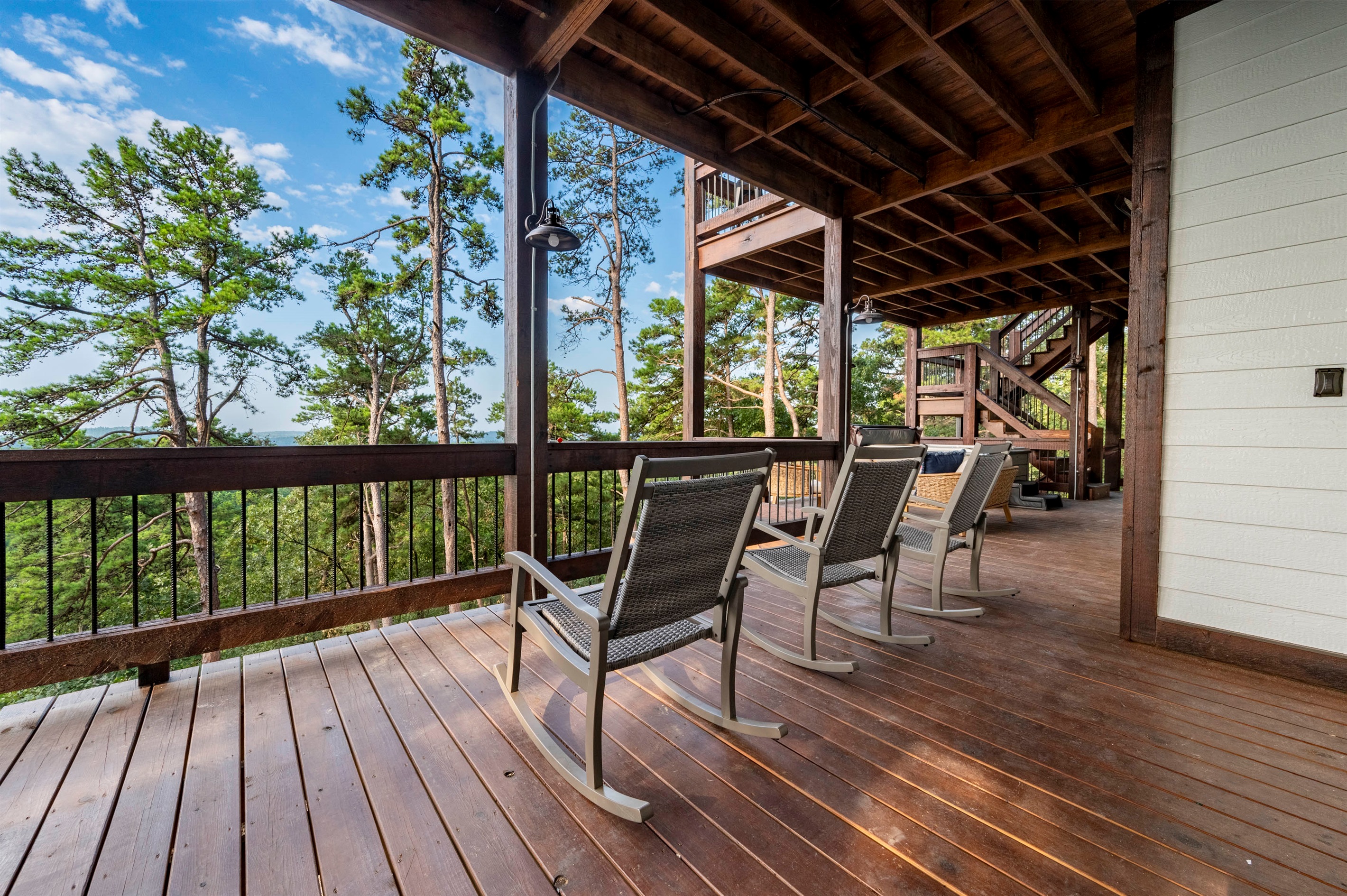 Spacious wraparound deck with relaxing seating surrounded by nature