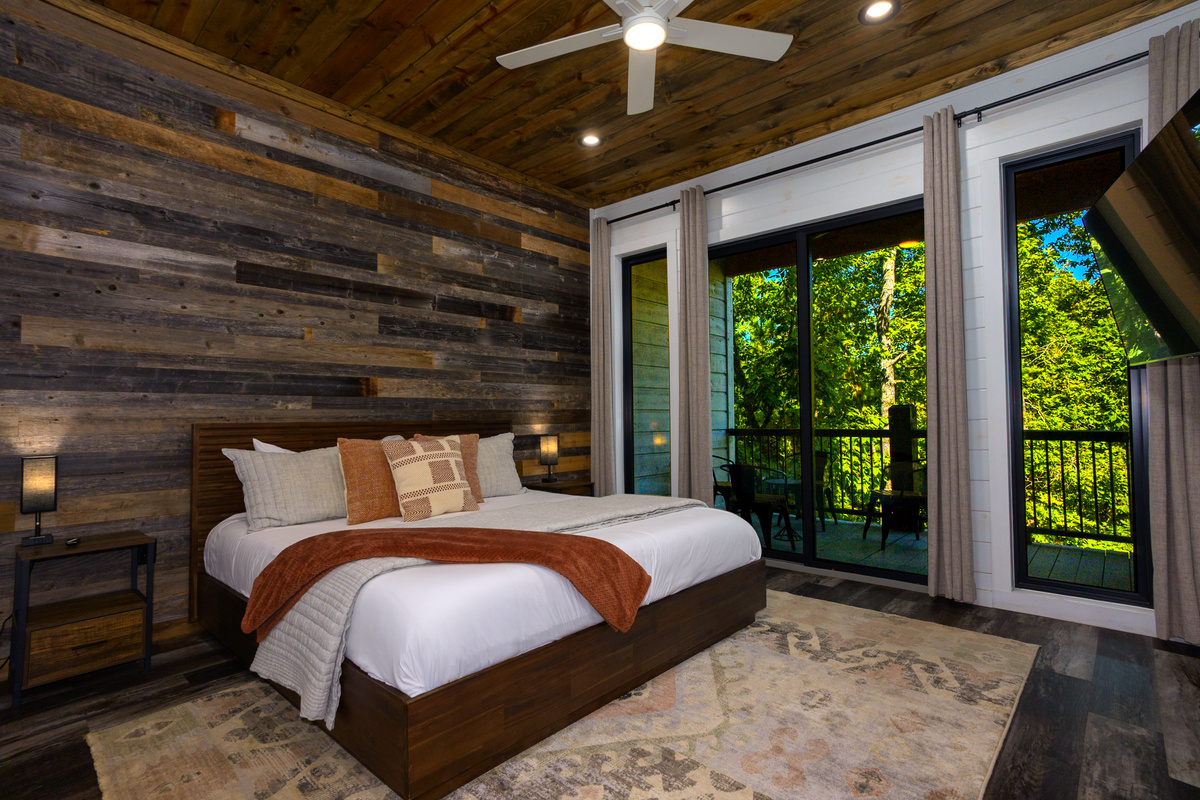 Bedroom designed with an inviting decor, cozy bedding and large windows with an attached patio to step out and enjoy nature!