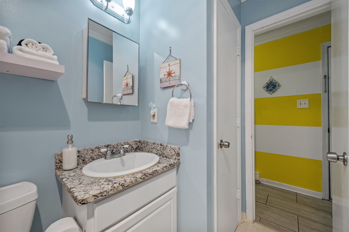 Clean and simple bathroom with nautical touches and everything you need after a day at the beach