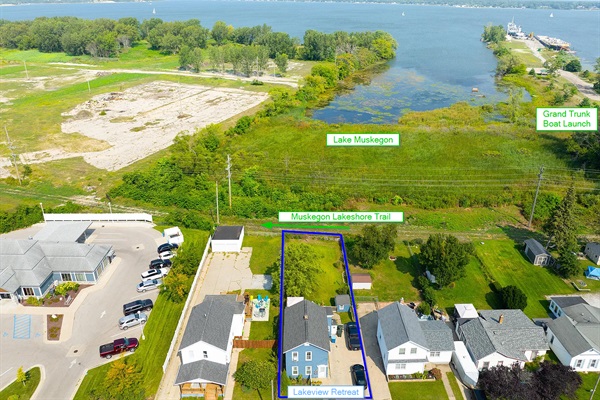The home backs onto Lake Muskegon, the Muskegon Lakeshore Trail, and a boat launch right next door (with a big driveway to park your boat!)