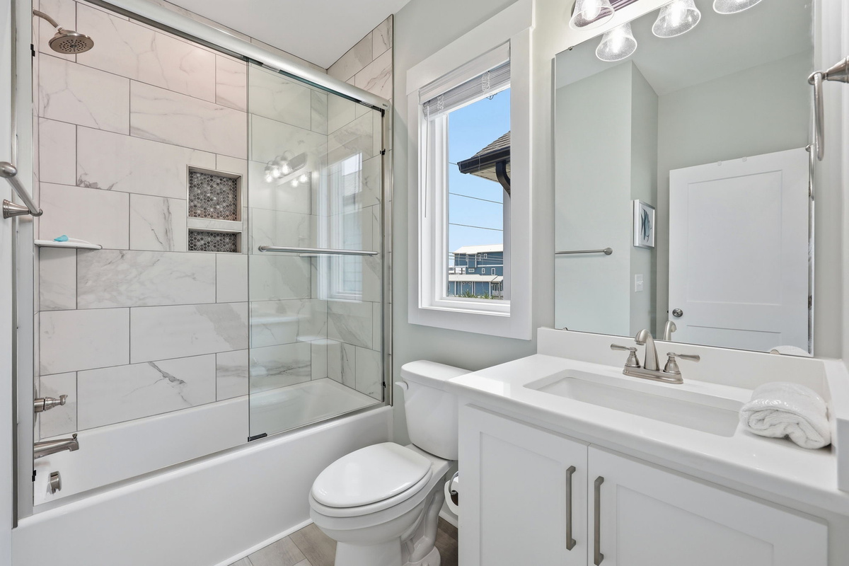 The private bathroom features a beautifully tiled walk-in shower with glass doors, creating a spa-like space to refresh and unwind
