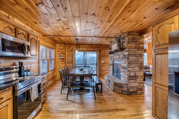 Dining area right off the fully-stocked kitchen that has seating for 12, with double-sided fireplace between dining area and living room.