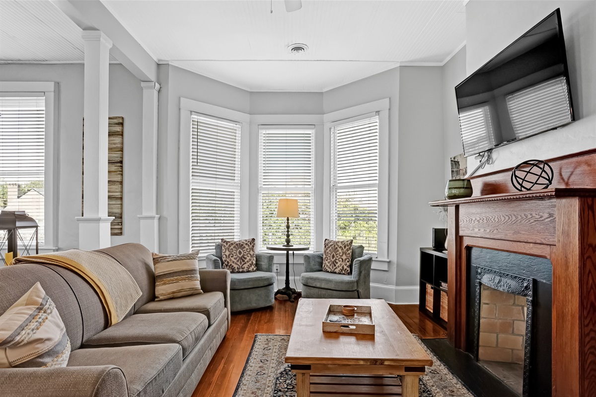 Natural light floods the space through a charming bay window.