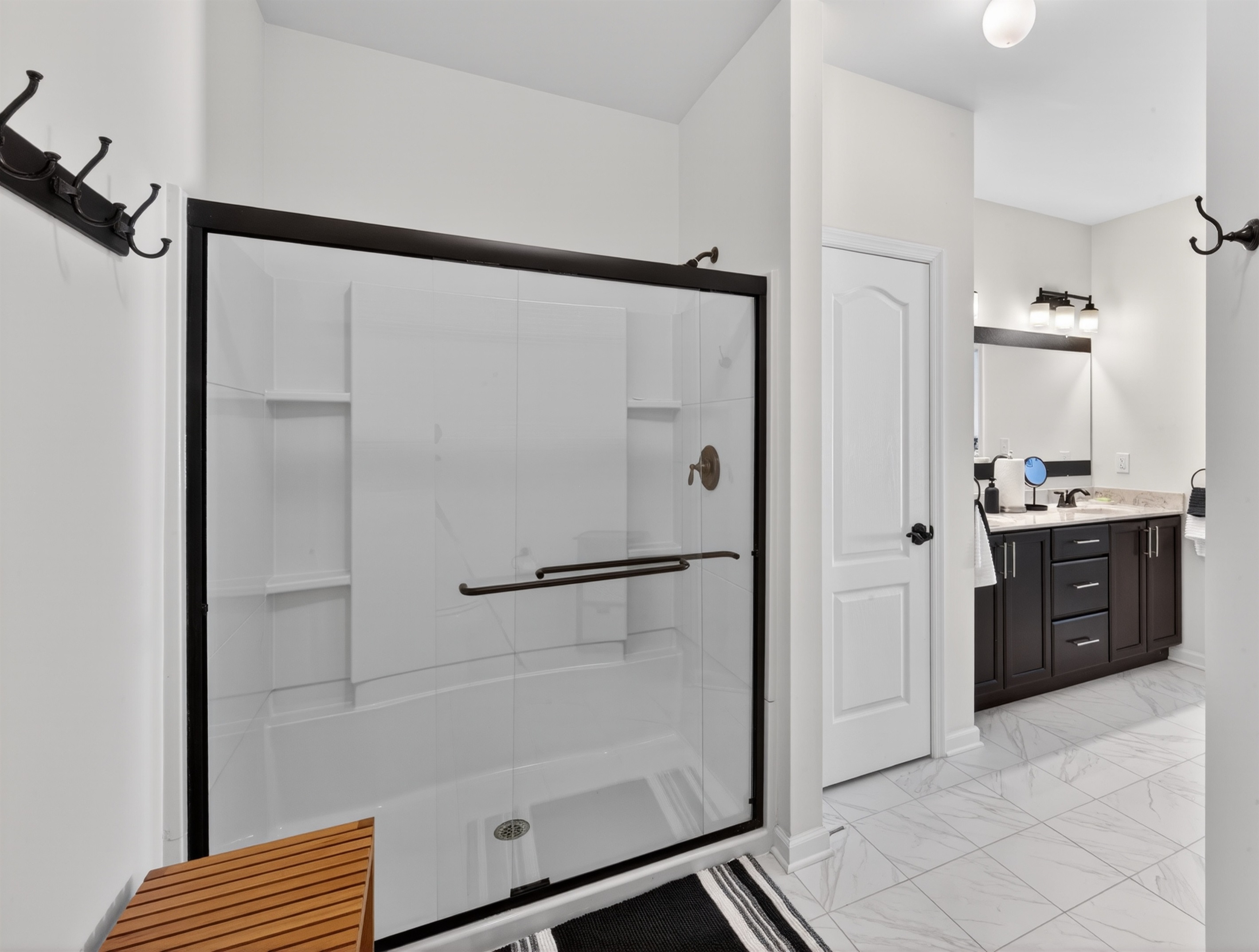 Large shower with bench and shower hooks, toilet tucked around the corner for even more privacy