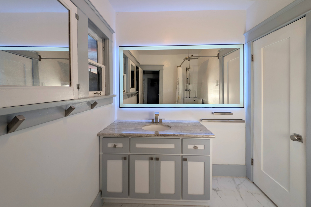 Fresh, clean, and thoughtfully designed, this stylish bathroom offers plenty of space to get ready for your day or unwind after the beach.