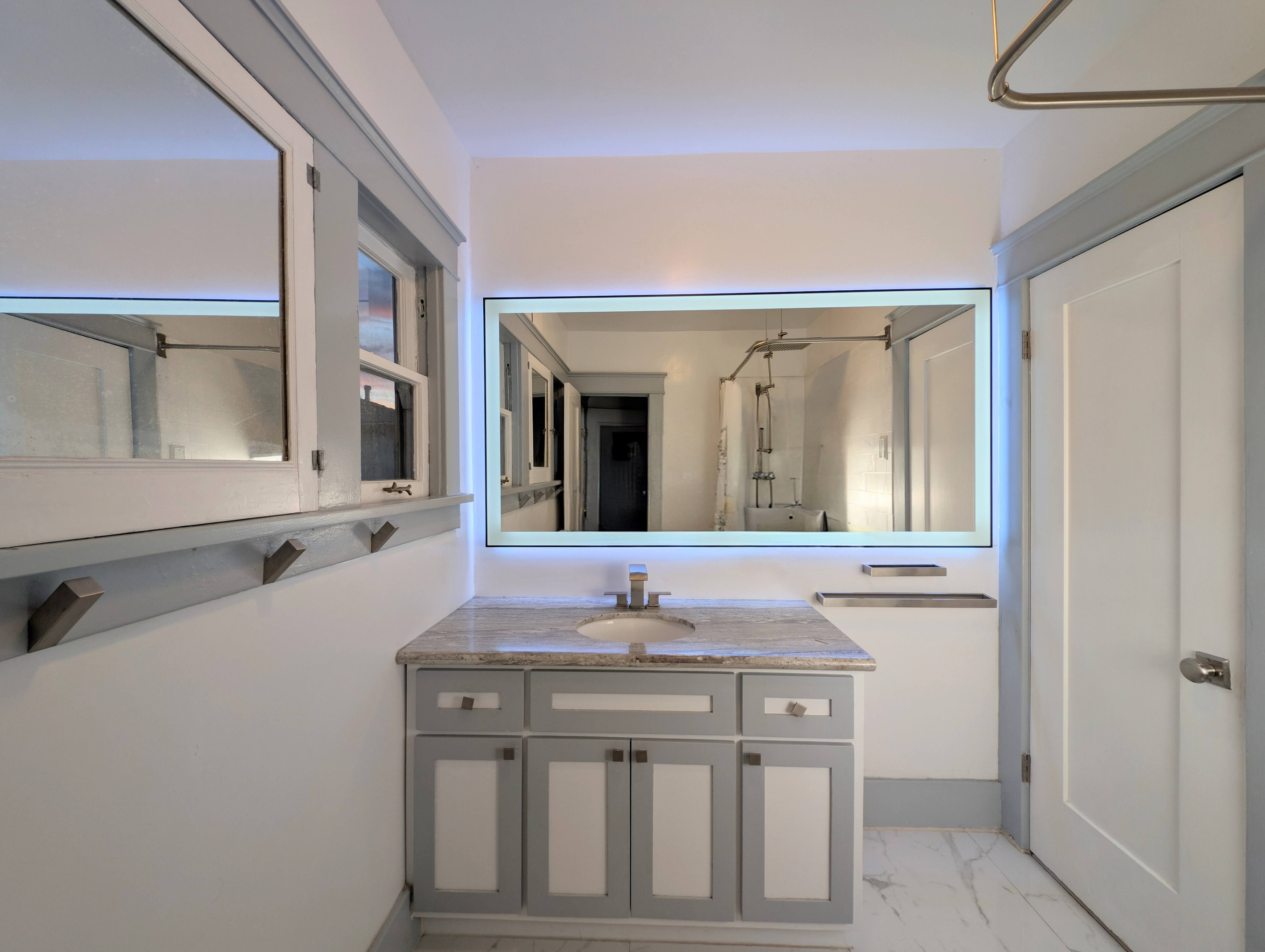 Fresh, clean, and thoughtfully designed, this stylish bathroom offers plenty of space to get ready for your day or unwind after the beach.