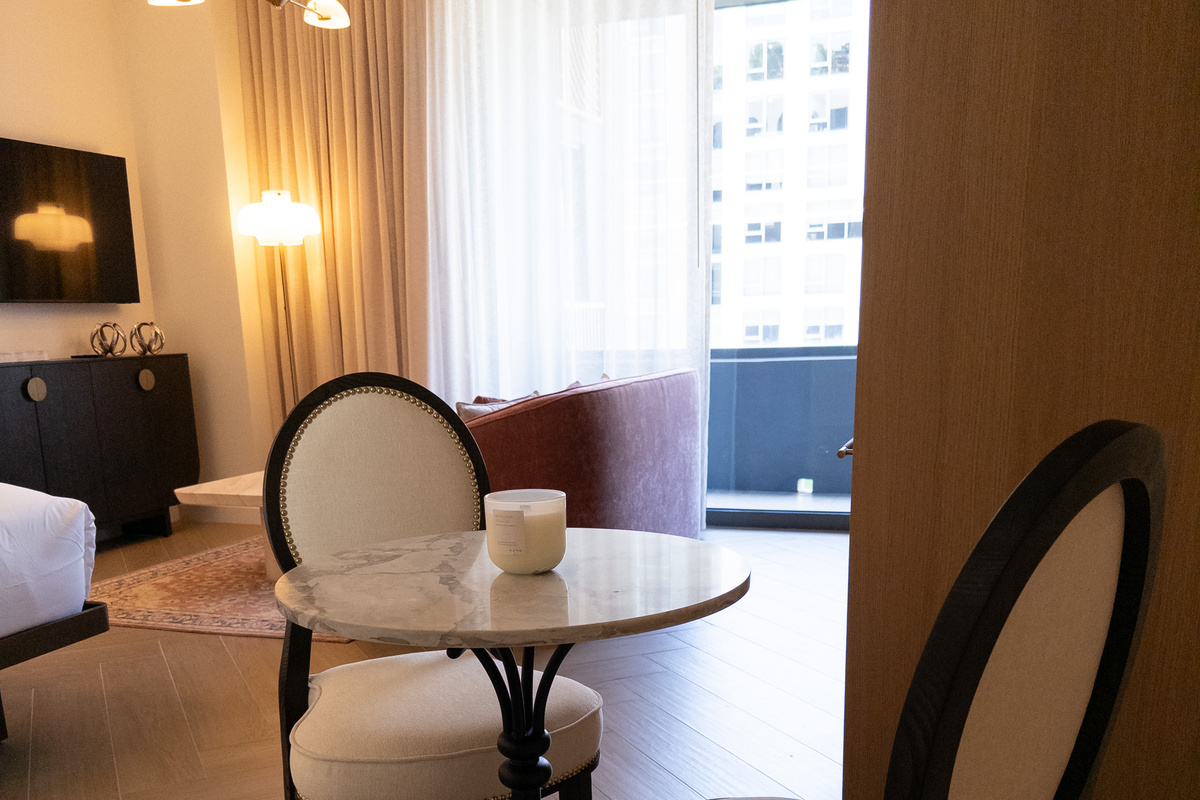 Dining-for-two nook - a round marble bistro table bathed in window light.