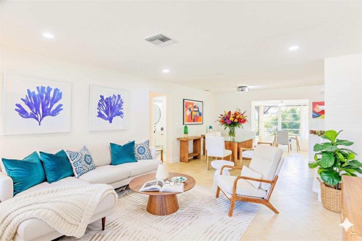 Beautifully designed living space with comfortable seating, coastal artwork, and a large Roku TV for entertainment.