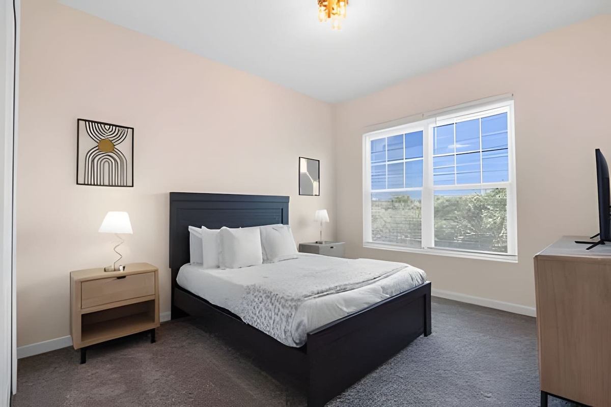 Relax in this airy, inviting bedroom with fresh linens and a comfortable bed.