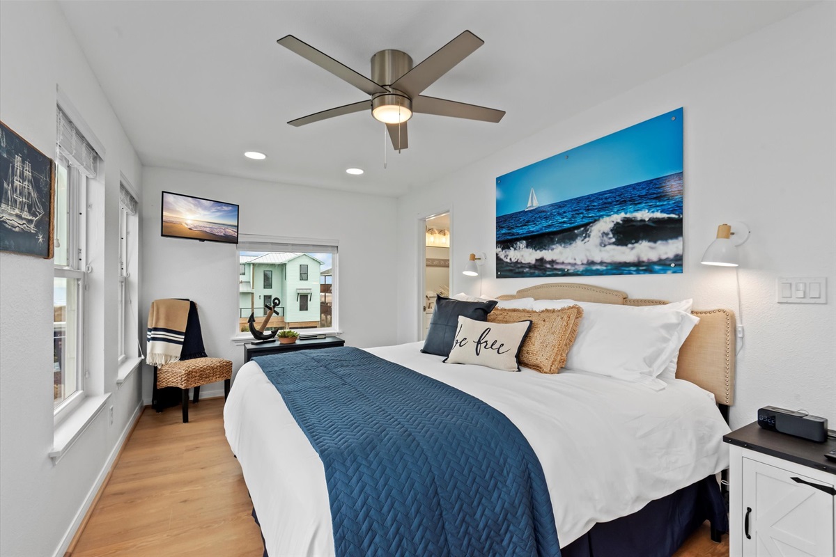 The Captain's Cove master bedroom boasts plush, comfortable linens and a TV, perfect for cozy late-night entertainment.