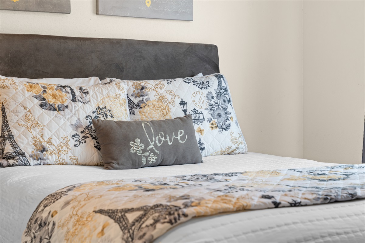 Layered bedding and bedside lighting keep the king suite feeling calm, simple, and restful.
