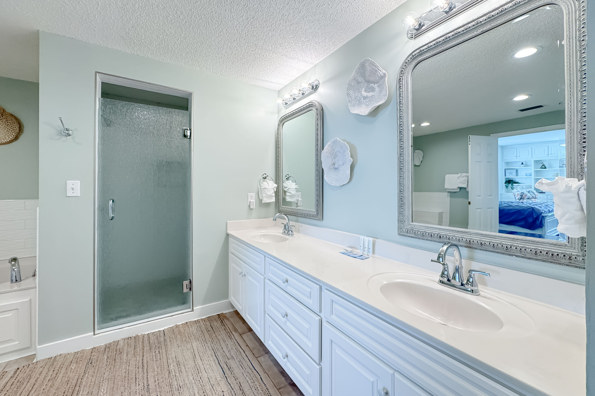This well-lit bathroom offers double vanity, ample space, and essential amenities.  A clean and inviting retreat.