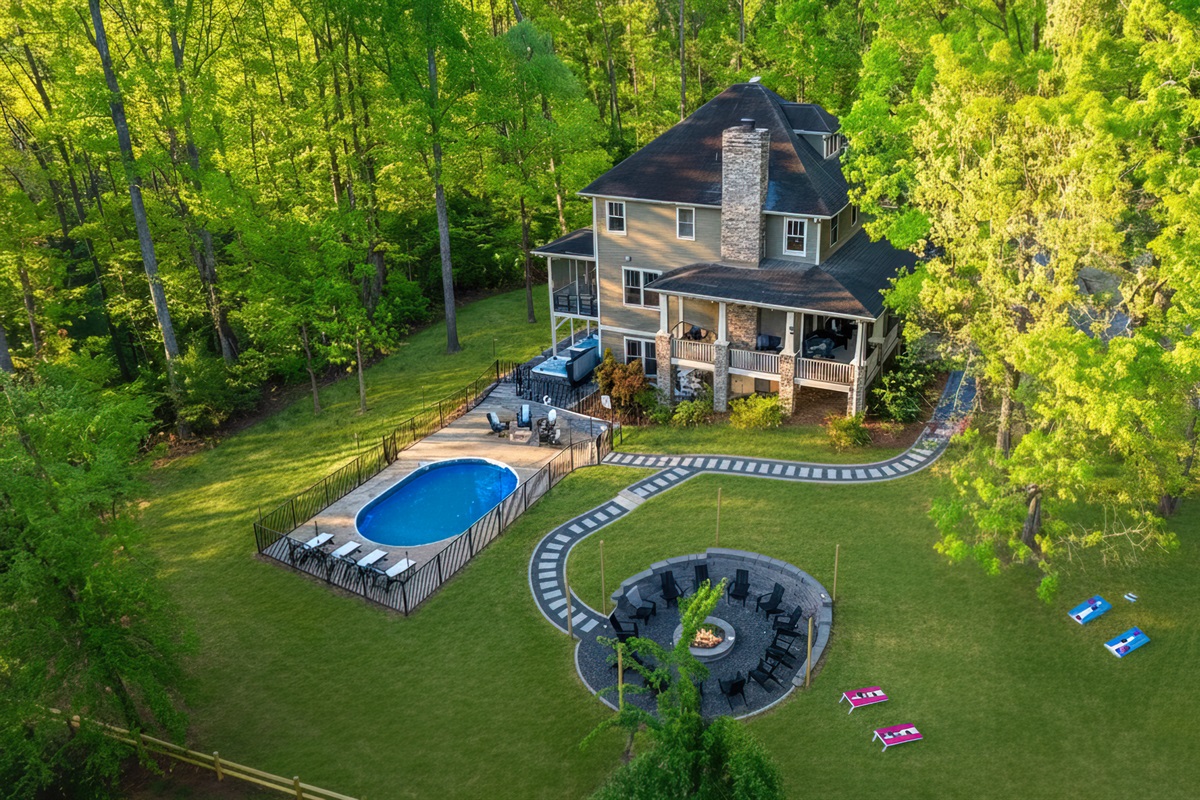 Tucked into the forest with seasonal mountain views, this luxury 8-bedroom retreat sleeps 22 and features a private pool, massive fire pit, 2 hot tubs, outdoor games, a game room, 2 kitchens, 6 king bedrooms & 5 ensuite bathrooms just outside Asheville NC.