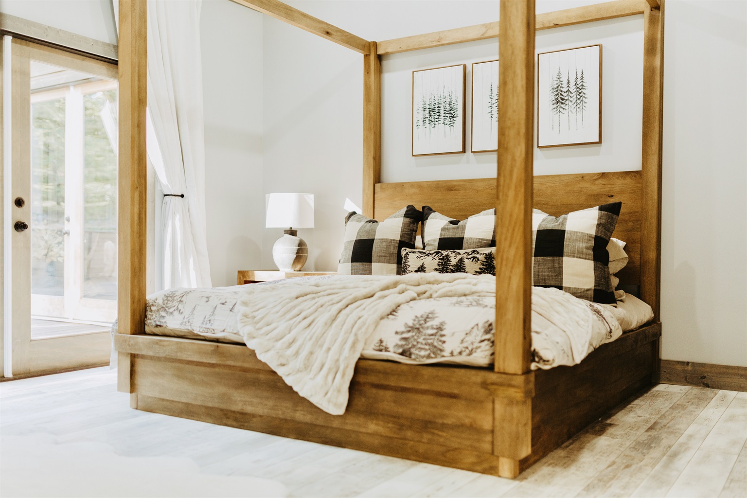 King suite with a canopy bed, vaulted ceiling, and forest views.