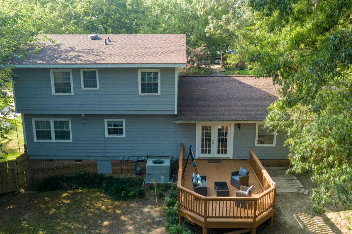 Private backyard with elevated deck and mature trees — a peaceful setting for outdoor meals, quiet mornings, or kids at play. 