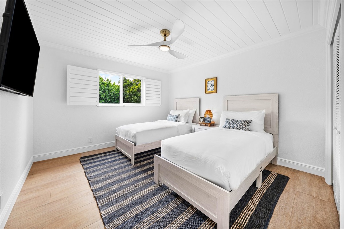 Designed for comfort and versatility, this bright guest room offers a relaxed beach-inspired setting perfect for family or friends.