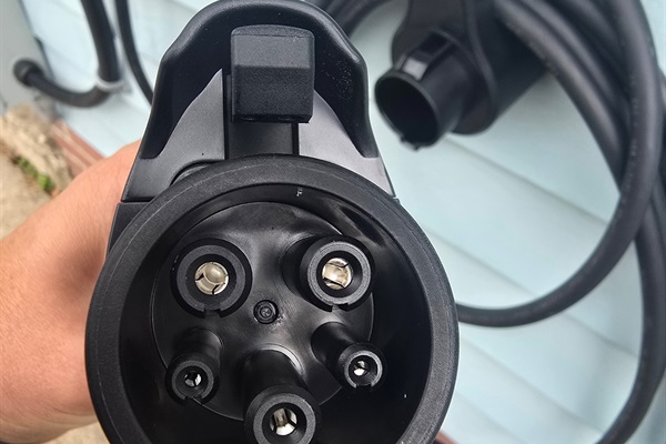 Close-up of our NEMA 14-50 setup—this heavy-duty attachment hose connects securely for Level 2 EV charging, delivering reliable power right from the side entrance. Just plug in, charge up, and hit the road.