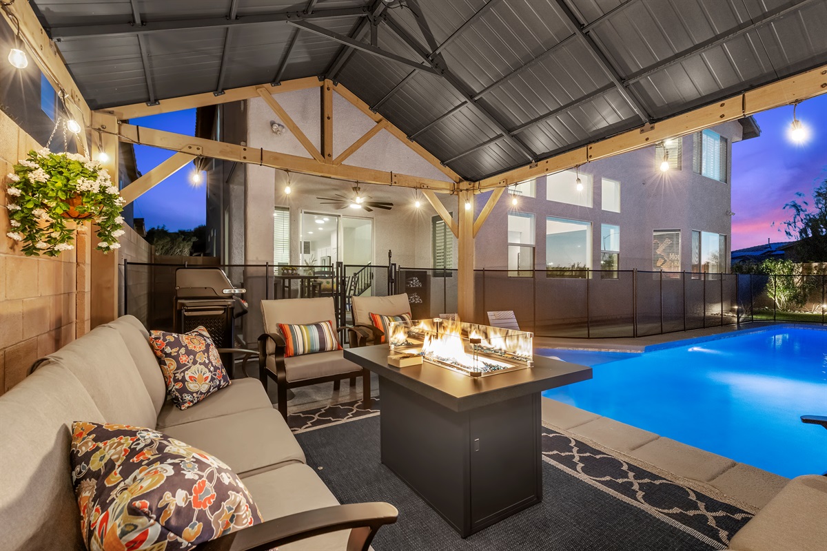 Cozy ramada that elevates outdoor living with a firepit and string lighting.  -It's Showtime!