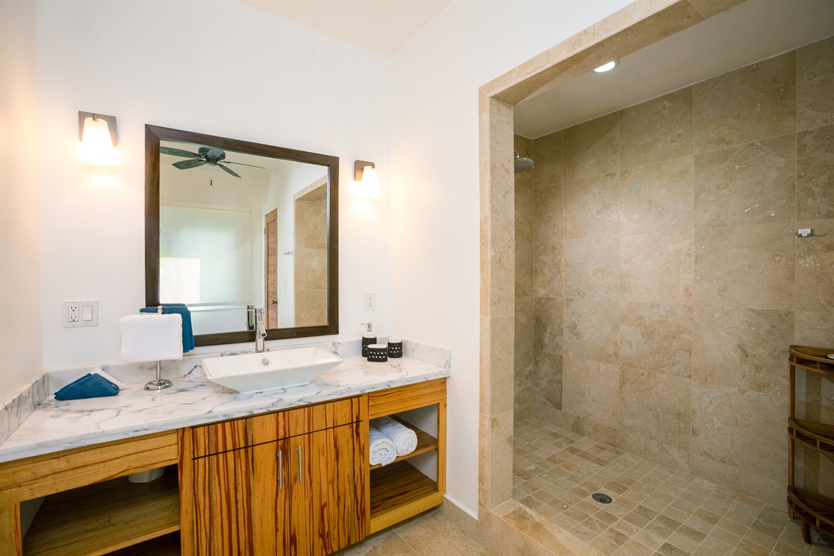 Our bathrooms feature sleek travertine finishes and an oversized walk-in shower. The natural stone creates a cool, spa-like escape, perfect for refreshing after a day on the beach. Pure island luxury in every detail. 🚿✨