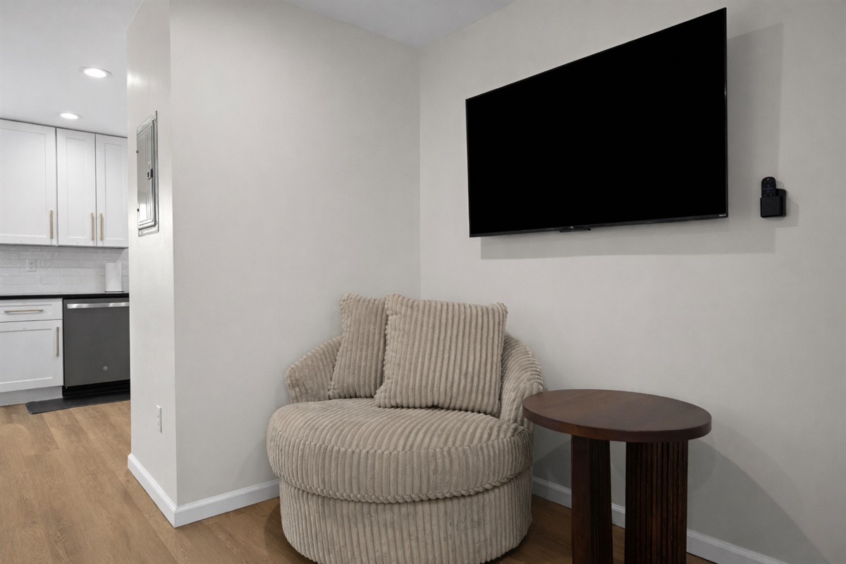 Cozy reading and relaxation nook with a plush accent chair, smart TV, and side table—perfect for unwinding, streaming, or enjoying quiet moments.