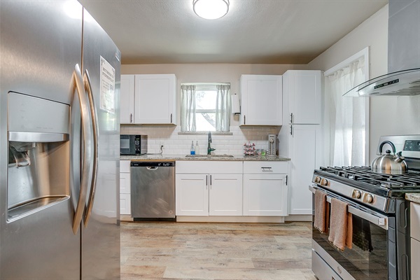 Modern kitchen with quartz counters, subway tile, and new appliances