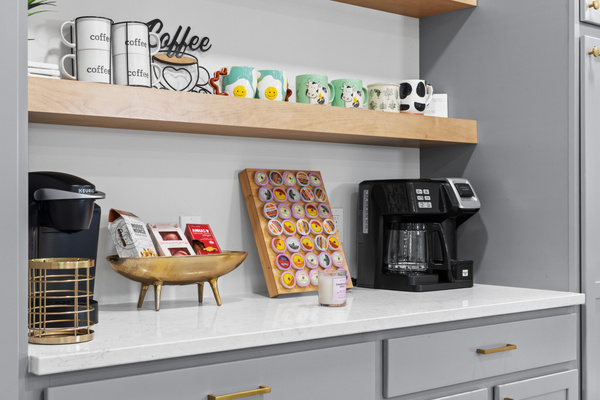 The coffee bar station features cute mugs, a drip maker, and a Keurig with complimentary pods.