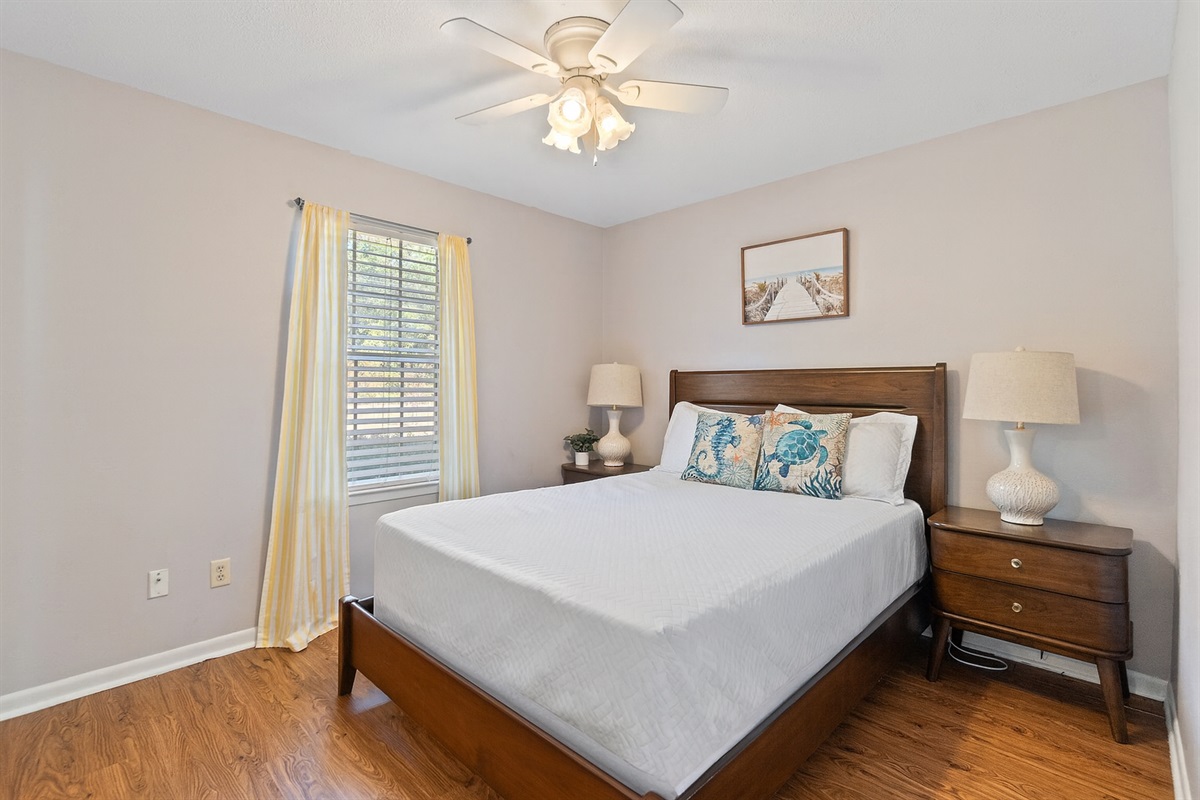 Cozy bedroom retreat with natural light, stylish decor, and a comfy queen bed for restful nights