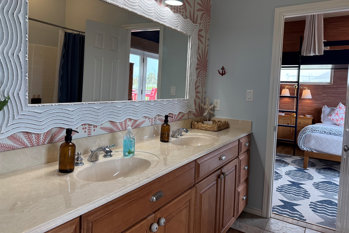 Double vanities and tub shower combo with plenty of towel hooks in the Hollywood Bathroom. 