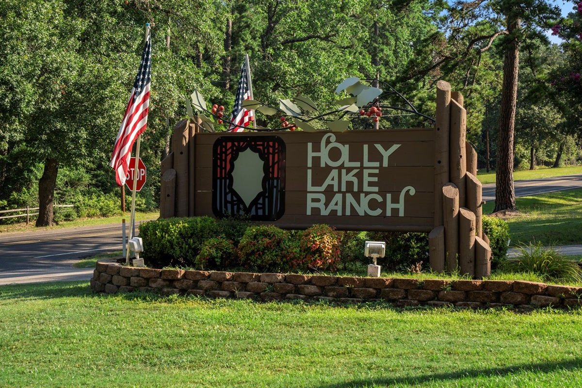 As you arrive, you’ll be greeted by the 'Welcome to Holly Lake Ranch' sign—a rustic, charming marker nestled among tall pines.