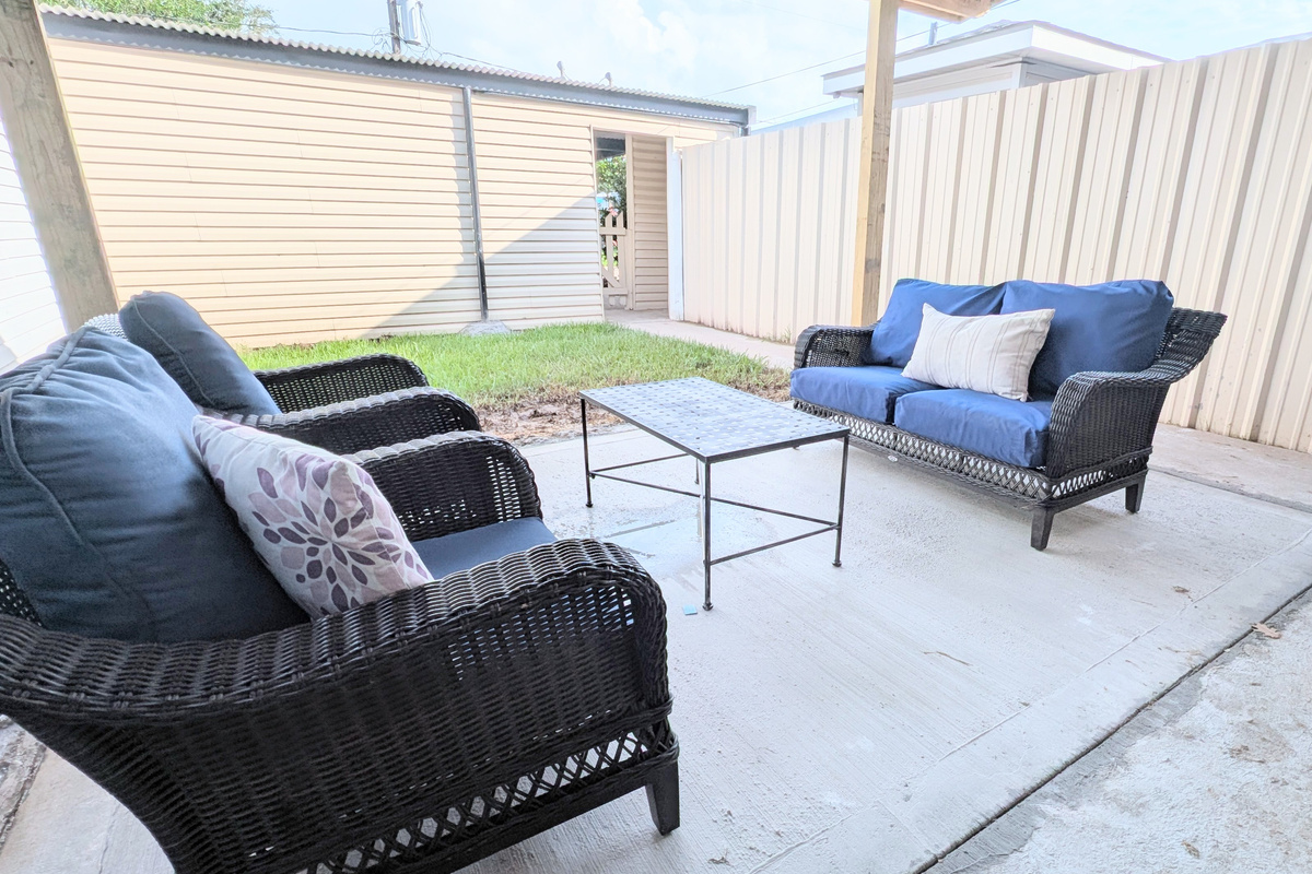 Relax on the covered patio with plush seating and a fenced courtyard. 