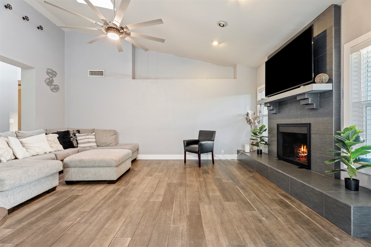 This stylish living room offers plush seating, a large smart TV, and fireplace ambiance designed for total relaxation and quality time.