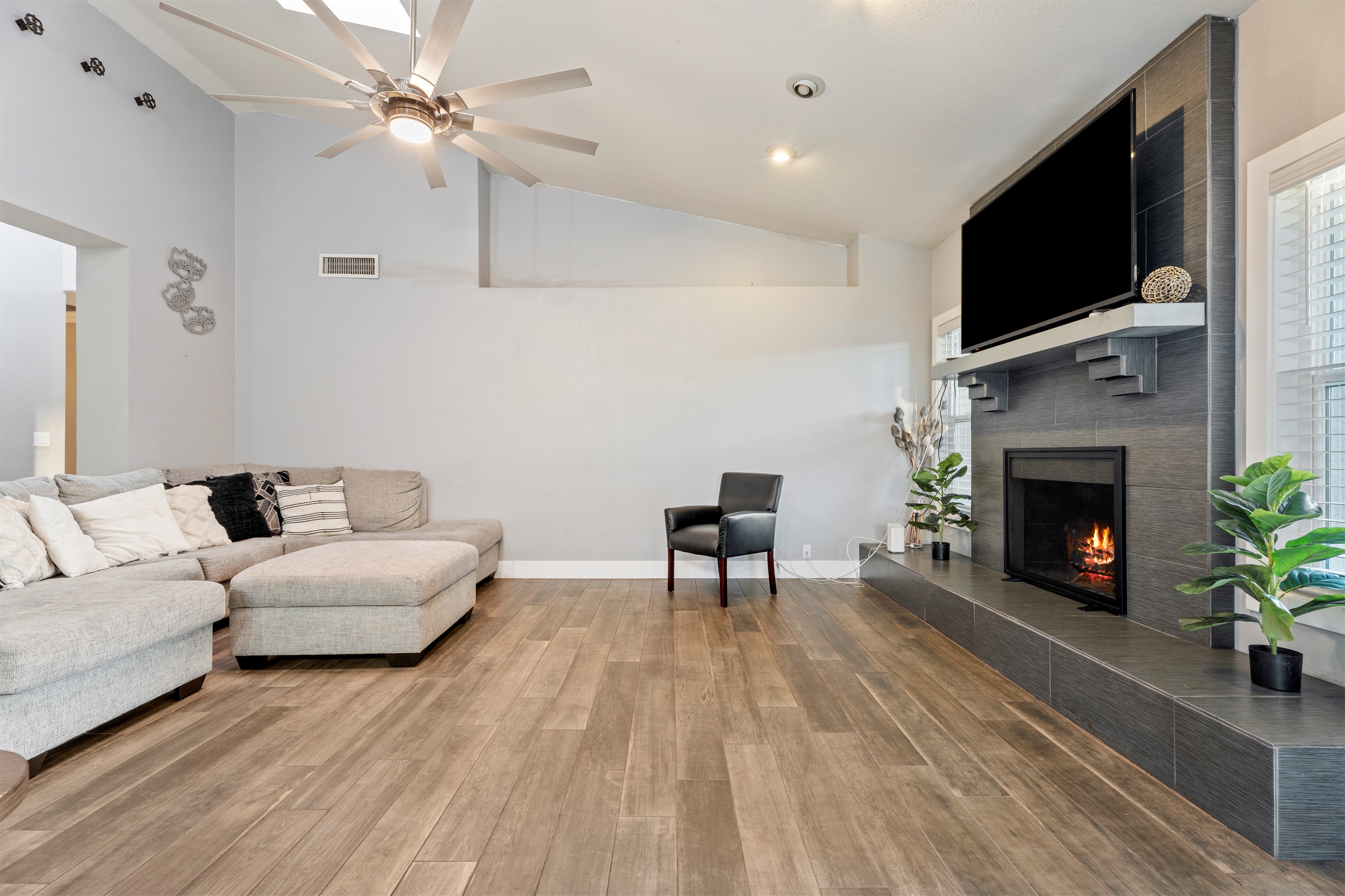 This stylish living room offers plush seating, a large smart TV, and fireplace ambiance designed for total relaxation and quality time.