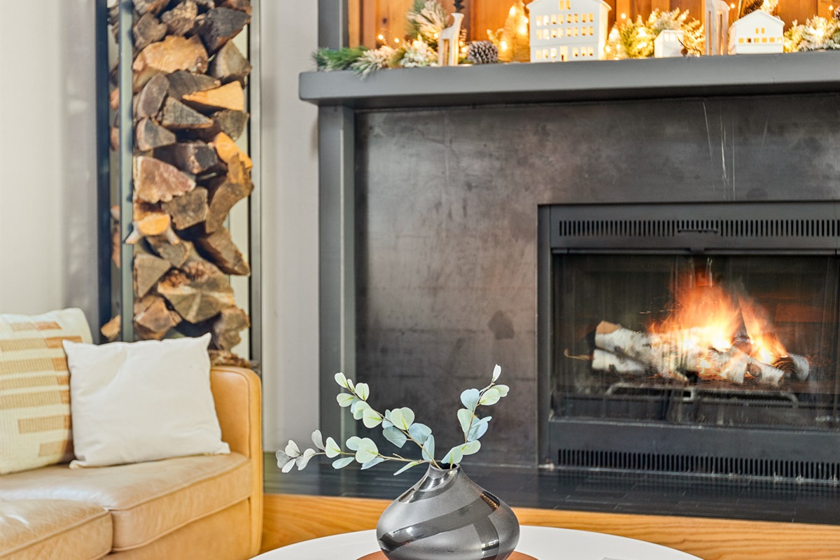 Cozy holiday fireplace with warm lighting, festive decor, and modern wood accents—perfect for a relaxing winter stay.